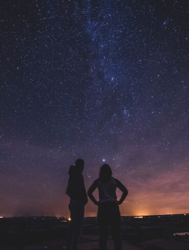 silhouette of people under milky way