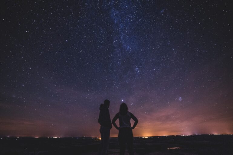 silhouette of people under milky way