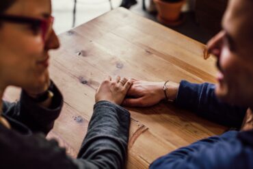 Man and Woman Sitting Together in Front of Table